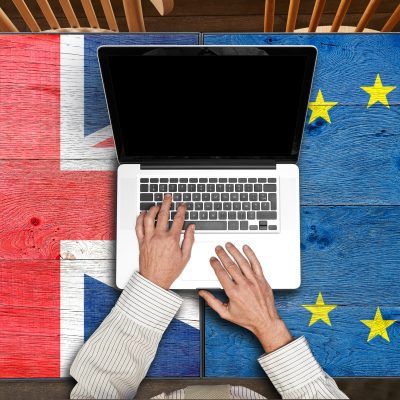 European and UK flagged wooden tables with laptop
