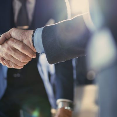 People in suits shaking hands in partnership